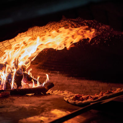 Pizzas dentro del horno de leña.